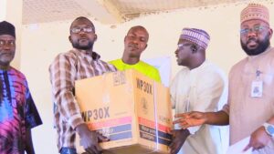 A farmer receiving his water-pumping machine from the National Lottery Trust Fund